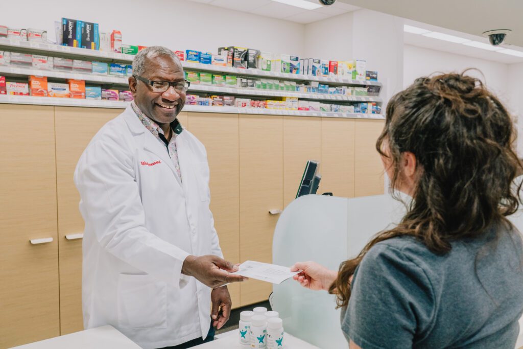 Walgreens pharmacist Calvin Bryant helping a customer.