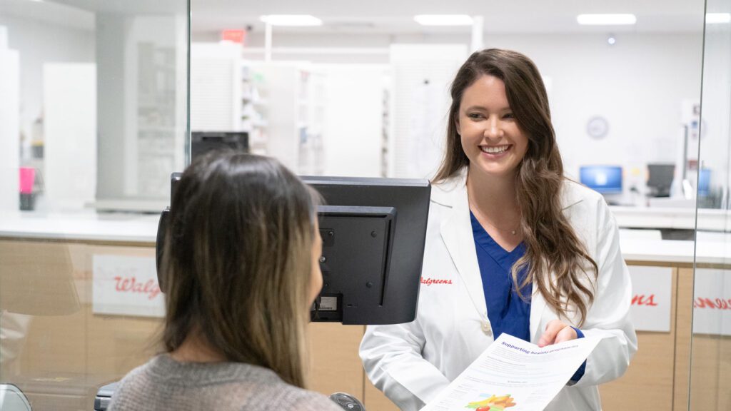 Smiling Walgreens pharmacist behind a counter.